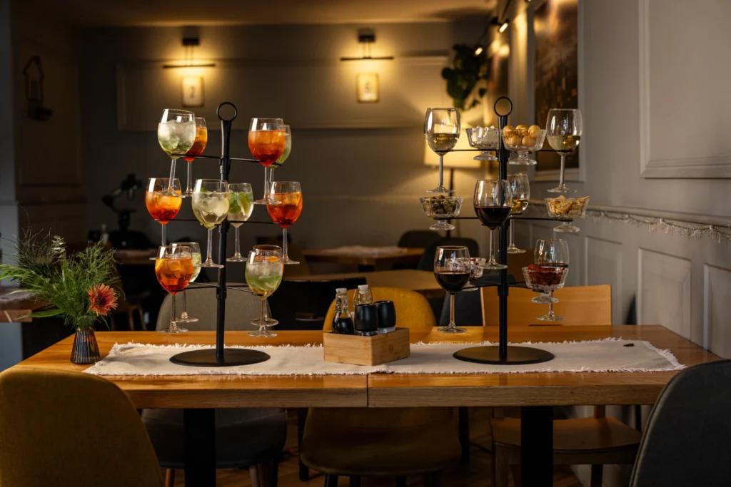 Elegancka aranżacja drinków i przekąsek na stole w restauracji Just Friends w Poznaniu, idealna na spotkania towarzyskie i kolacje integracyjne w Poznaniu.